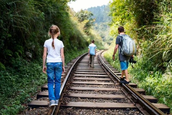 depositphotos_183786028-stock-photo-family-walking-along-train-tracks